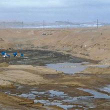 A big sign, stating: “Diamond theft hurts us all – Don’t do it”, is one of the first things visitors see when they arrive at the small airport of Oranjemund, Namibia. Oranjemund, meaning mouth of the Orange River is situated in the far south western corner of Namibia. The town was established in 1936, following the discovery of diamonds on the north bank of the Orange River. Accessing the town is impossible without a special permit issued by the Namibian Ministry of Mines and Energy. Diamond theft is a big concern, for Oranjemund which is located within one of the richest diamond fields in the world. In order to prevent diamond theft, Namdeb has installed FLIR Systems thermal imaging cameras. Oranjemund and Namdeb Diamond corporation Diamonds originated deep in the interior of Southern Africa. Over millennia, the Orange River carried them to the Atlantic Ocean where they were deposited on ancient beaches, which in time became part of the mainland. Prior to the discovery of diamonds in the Namibian desert, some prospecting had taken place along the coast as early as 1863. In 1908, a railway worker Zacharia Lewala, stumbled on a shiny treasure that started a major diamond rush. As a result, diamond mining regulations were introduced in 1911 and the Sperrgebiet or “forbidden territory” was declared. In 1920, Sir Ernest Oppenheimer formed Consolidated Diamond Mines of South West Africa (CDM). Oranjemund, a unique town that owes its existence to diamond mining, was established in 1936. It services the Mining Area 1 and Orange River mines. In 1994, an agreement between CDM and the Government of the Republic of Namibia resulted in the formation of Namdeb Diamond Corporation (Pty) Limited. Namdeb Diamond Corporation (Pty) Limited is owned in equal shares by the Government of the Republic of Namibia and De Beers Centenary AG. Namdeb's predecessor, Consolidated Diamond Mines (CDM), was a wholly owned subsidiary of De Beers until 1994. All of the De Beers group's existing Namibian mining licenses and related rights were replaced by a consolidated and rationalised mineral agreement, drawn up under Namibia's postindependence mineral legislation. Different mining processes to find diamonds Diamonds were formed at least 990 million years ago, although some are estimated to be as many as 4.25 billion years old, thereby pre-dating life on this planet. Diamonds are formed at pressures of 45-60 kbar. This corresponds to a depth of 125-200 kilometers below the Earth’s surface where the pressure is around fifty thousand times that of atmospheric pressure at the Earth’s surface. Different ways exist to extract diamonds: • Open-pit mining, where diamond deposits are on the surface of the ground - Underground mining, where diamond deposits are below ground • Alluvial Mining, where diamonds are extracted from alluvial deposits and are removed from sand, gravel and clay • Alluvial mining is undertaken by either coastal and inland mining where sand and soil are removed to find diamonds or by marine mining where diamonds are extracted from the seabed. Alluvial mining, cleaning the bedrock Namdeb Diamond Corporation (Pty) Ltd. is the world’s leading alluvial diamond miner. It extracts diamonds from sand, gravel and clay using the open-pit method. The process involves removing the overlying ground and then extracting the diamonds. The first step in the mining process is to remove the overburden – the surface material covering the diamonds. This can be up to 40m thick and can vary from loose sand to cemented conglomerate. Most of the ore is excavated by trackdozers and excavators. They create windows from which front-end loaders remove ground and place into haultrucks. The bottom part is called bedrock. This underground is hard as a rock and it is the bed on which the diamonds were deposited by the river so many years ago, and resting. The bedrock is cleaned by workers using a containerised vacuum cleaning system. Once excavated, the ore is transported to ore processing plants where it is crushed to pieces smaller than 150mm. A process of dense medium separation produces a diamond-rich concentrate from the crushed gravel. The final concentrate represents around 1% of the material originally fed to the plant. The concentrate is sent to a central recovery plant, which produces the final 100% diamond product. Mining aria 1 and Bogenfels mines Namdeb currently holds multiple mining licenses from which diamonds are recovered. The Mining Area No.1, Bogenfels and Elizabeth Bay Mining Licenses extend from the Orange River in the south to Lüderitz in the north of Namibia, and approximately 5.5 kilometers off shore in the Atlantic Ocean to approximately 20 to 35 kilometers inland. These areas generate the bulk of Namdeb's production. Diamonds are very small and easy to conceal. Therefore making sure that as little as possible diamonds are being stolen is of the utmost concern to Namdeb. Using ingenious methods to steal diamonds “Diamond theft is serious issue”, explains Mr. Freddie Groenewald, Security Chief Technician at Namdeb, Oranjemund. “Our mines are very rich and produce stones of the highest quality. Most of our product is gem stone quality, used for jewellery, with only a very small percentage of industrial stones. Our mines are so rich that workers that are working on the bedrock, the bottom layer where the diamonds are situated, regularly spot diamonds with the naked eye. If a worker picks up a diamond and hands it over, Namdeb’s experts will determine the value of the stone and 70% of its value is given to the honest finder. This way we try to discourage theft. Nowhere else can a worker gain this amount of money for a precious stone.” “Still, numerous people are trying to steal the diamonds. At first sight this seems unbelievable since at the “black market” they will only receive a small amount of the stone’s value. The problem is that workers are sometimes under pressure from criminal organisations to steal diamonds. Although strict security measurements are in place, they still try to steal using different methods. Since all people that come out of a secure area are scanned, various methods to conceal diamonds are used, for example hiding them in the heels of shoes or in work tools.” Security at the bedrock area “Needless to say, that the bedrock area is a critical area for security.”, explains Mr. Harold Schoeman, Security Senior Technician at Namdeb, Oranjemund. “We monitor the workers closely to see that they are not trying to take away diamonds. We have introduced movable wireless camera systems called “spider cameras” on the bedrock mining sites. These are small, movable CCTV cameras installed on the bedrock, close to the workers. We can zoom in and follow their activities from a centralised video monitoring facility. The camera systems have assisted us with good quality video footage, which are used as evidence in disciplinary actions and in court cases of diamond theft.” Thermal imaging helps for security during the night “The workers are aware that they are being monitored so they are careful of what they do. Sometimes they hide stones in a remote area of the bedrock area. Once it is dark, they will try to come back and pick up the diamonds. In order to avoid this we have installed thermal imaging cameras.”, says Mr. Groenewald. “We have installed mobile surveillance systems on all active bedrock sites. These systems include a FLIR Systems SR-100 thermal imaging camera.” “There is not supposed to be any activity on the bedrock sites during night time and if anyone does try to access it in darkness to pick up diamonds, we see it immediately on one of our monitors. Since the cameras are installed on a pan/tilt head, we can follow the person while a security patrol is on the way to arrest him. The cameras do not help us only during the night. The area where we are mining is close to the sea and foggy conditions are not unusual. The thermal imaging cameras also help us to see through the fog.” FLIR Systems SR-100 cameras “We recently purchased 16 FLIR Systems SR-100 cameras to overlook the bedrock areas. We had experience with other thermal imaging cameras in the past and were very much aware how thermal imaging can help us. We decided however to buy FLIR Systems thermal imaging cameras for various reasons.”, Mr. Groenewald continues. “The FLIR Systems cameras contain a Vanadium Oxide detector and produce an excellent image on which the smallest of details can be seen. Since they are producing images with a frame rate of 9 Hz we did not need any export license to install them in Namibia. The 9 Hz images are not a problem for us and suit our needs perfectly. Furthermore, the cameras which we had installed previously contained a BST detector. In order to operate well, they contain an internal mechanical chopper that calibrates the image. This chopper was very susceptible to breakdowns. Each time we had to send a camera in for repair it was away for quite some time. By buying FLIR Systems material we are eliminating all these problems. We are convinced that we are getting excellent value for our money.” Operating under climatically harsh conditions “The cameras we are operating on the bedrock areas are operating in extremely harsh conditions. Not only are they installed close to the sea, which means they are susceptible to salt spray, they are also exposed to strong winds. It is like their housing is being sandblasted continuously.”, Mr. Groenewald continues. “Although the cameras are extremely well protected, we decided that they could use some extra protection in these conditions.”, explains Mr. Tinus Diedericks, Timeless Technologies FLIR Systems distributor in South Africa. “Therefore we have constructed “Stainless Steel 316” housing. The FLIR Systems SR-100 cameras are installed in the housing together with a CCTV camera which overlooks the bedrock during daytime. The housing containing the two cameras is installed on a pan/tilt which increases situational awareness and allows following people when necessary. ” “To protect the lens of the SR-100 cameras we have installed an 8 mm thick germanium window. More than 99% of the infrared radiation transmits through it. The germanium window has been hardened with cobalt on the outside and has an anti-reflexive coating on the inside. This way we can assure a perfect image quality and extremely high protection of the thermal imaging cameras.” Movable systems “The cameras and other equipment are powered by solar energy. A solar panel provides more than enough power to operate. Batteries, which can last up to 4 days, are being used as a back-up. The entire system has been installed on a small trailer. This way, Namdeb has the possibility to move it from one mining area to another. Once an area is mined out, they can easily move it to the next one without any problems.”, Mr. Diedericks explains. Monitoring the images in the control room The control room where all the images of the different camera systems are coming in is in Oranjemund. Some mining areas, like e.g. Bogenfels, are more than 200 kilometers away from this control room. “It works really simple!”, explains Mr. Diedericks. “The small spiders cameras installed on the bedrock are connected wireless to the station on which the thermal imaging cameras are installed. From this station, all signals are send wireless to a small local control room. This again allows for moving the cameras easily to a new location. A fiber optic cable goes from these control rooms to the main control room in Oranjemund. There the images of all cameras can be monitored and the cameras can be controlled.” Monitoring the entrance and exit of mining area 1 Not only the bedrocks are being monitored with thermal imaging cameras but also the exit and entrance to Mining Area 1 is being overlooked by a thermal imaging camera. All personnel and equipment that goes in or out, this area undergoes thorough security screening. When coming out of the area, everyone goes through an X-ray machine to check if they have not concealed diamonds. The entrance to Mining Area 1 is in the town of Oranjemund itself. Between the mining area and the town a “no-man’s land” has been created. In this “no-man’s land” dogs are patrolling continuously to make sure that no one tries to enter or leave the area in an unauthorised way. FLIR Systems PTZ-35x140 MS overlooks critical areas “Although we also have other equipment in place, we monitor the entrance and exit to Mining Area 1 and the “no-man’s land” continuously with a FLIR Systems PTZ-35x140 MS thermal imaging camera.”, Mr. Groenewald continues. “The camera is installed on a high mast on which also our communication and other equipment is installed. During daytime, we can use the daylight camera installed in the PTZ-35x140 MS. When it gets dark we switch to thermal. The PTZ-35x140 MS has the ability to zoom in and have a closer look at suspect activities which is perfect for us.” “One of the ways in which people are trying to get diamonds out of the mining area is by shooting crossbow arrows over the “no-man’s land”. The arrows are hollow and the inside is filled with diamonds. An accomplice picks up the arrows on the other side. Thanks to the PTZ-35x140 MS, we can now monitor, in total darkness and also in foggy conditions, what is happening alongside the fence. If we see people approaching and suspect illegal activity we send out a patrol. Since the PTZ-35x140 MS is mounted on a robust pan/ tilt mechanism, we can overlook an entire area and if necessary follow a suspect person so that he cannot get away.” Advantages of thermal imaging compared to fences are clear. More projects are being considered “Thermal imaging cameras have proven their worth here in Oranjemund.”, continues Mr. Groenewald. “They are an excellent tool for spotting activity in total darkness and in harsh weather conditions.” “Thermal imaging provides us with other options as well. At Namdeb we are trying to work in an ecological friendly way. If a mining area is mined out, we rehabilitate the area to its original state. Although sometimes fences are necessary, we try to avoid them as much as possible. We are investigating thermal imaging to further assist us with perimeter protection. This may reduce the civil works cost for expensive fencing options.” Thermal imaging for more than security only “With the advanced knowledge gained by working with thermal imaging cameras, I also want to use the technology for activities I do in my spare time.”, continues Mr. Groenewald. “Apart from being an amateur photographer I am technically assisting a scientist, Dr. Ingrid Wiesel, with the Brown Hyena Project. We are researching the behavuior of this fascinating animal that lives in the Namibian dessert. We would like to install a small thermal imaging camera, in co-operation with Tinus Diedericks from Timeless Technologies, in front of one of the dens to see exactly what happens during the night. After all, for seeing what is going on in total darkness, for security or any other application, there is no better tool than a thermal imaging camera.”, Mr. Groenewald concludes.